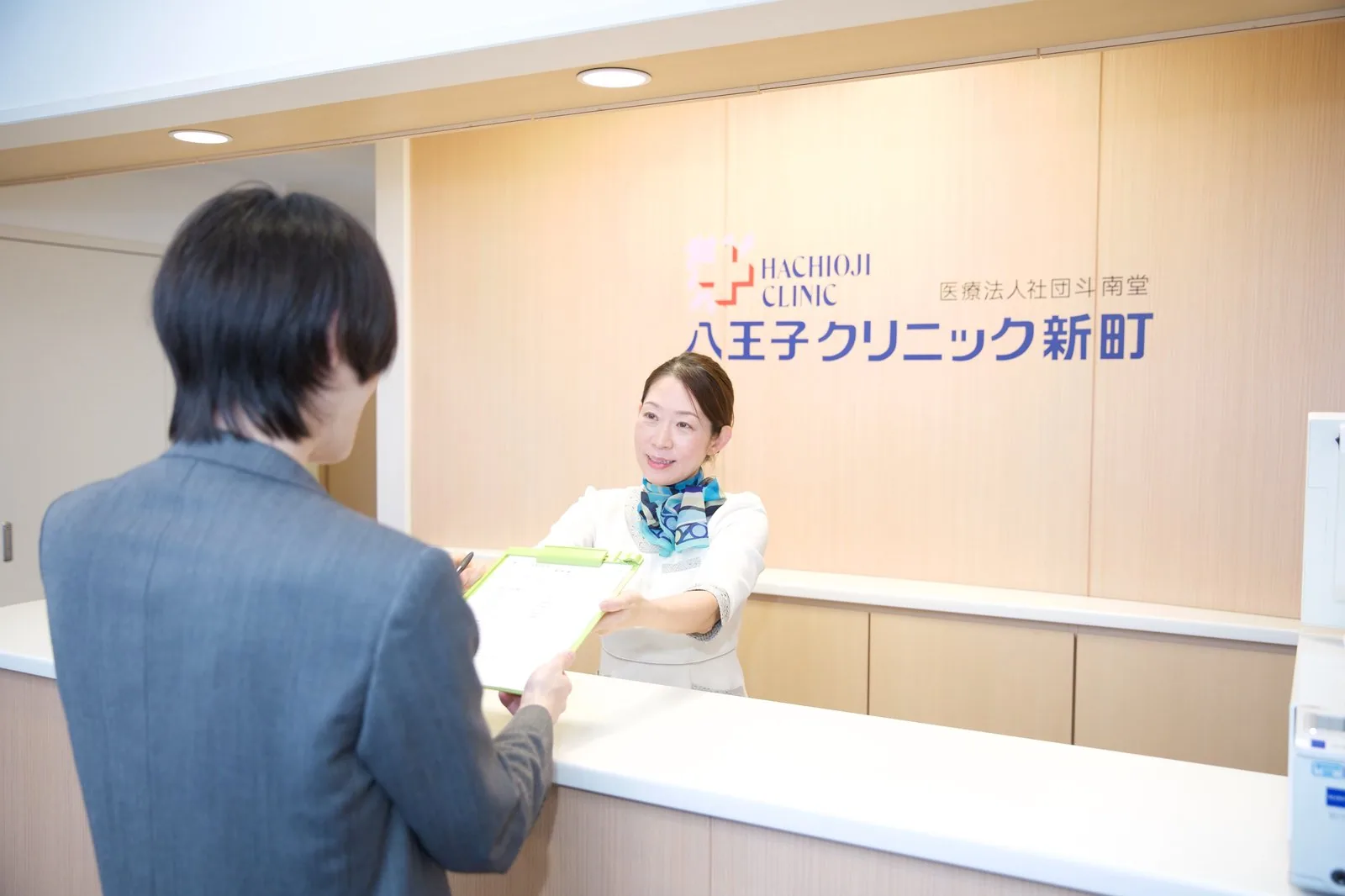 受付でご案内するスタッフ