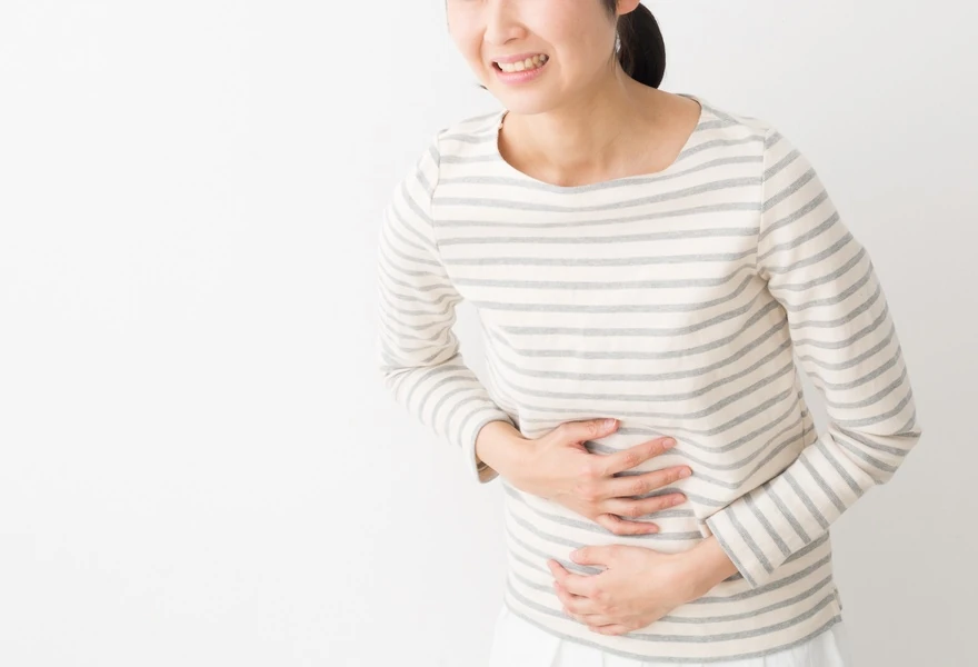 胃の不快感を訴える女性